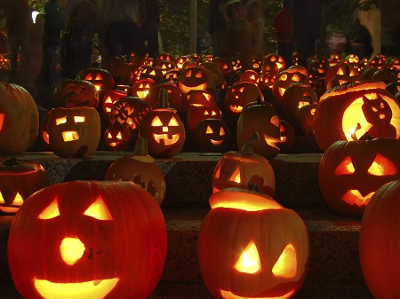 lots of pumpkins carved as Jack-o-Lanterns for Halloween lit on stairs