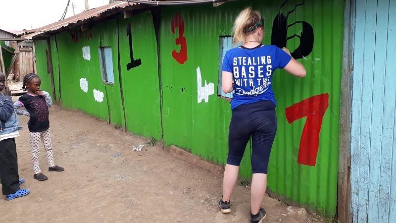 Izzy, a Porridge and Rice volunteer from Liverpool, helps to paint Excel school in the Nairobi slums